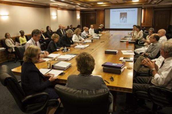 faculty around a long meeting table